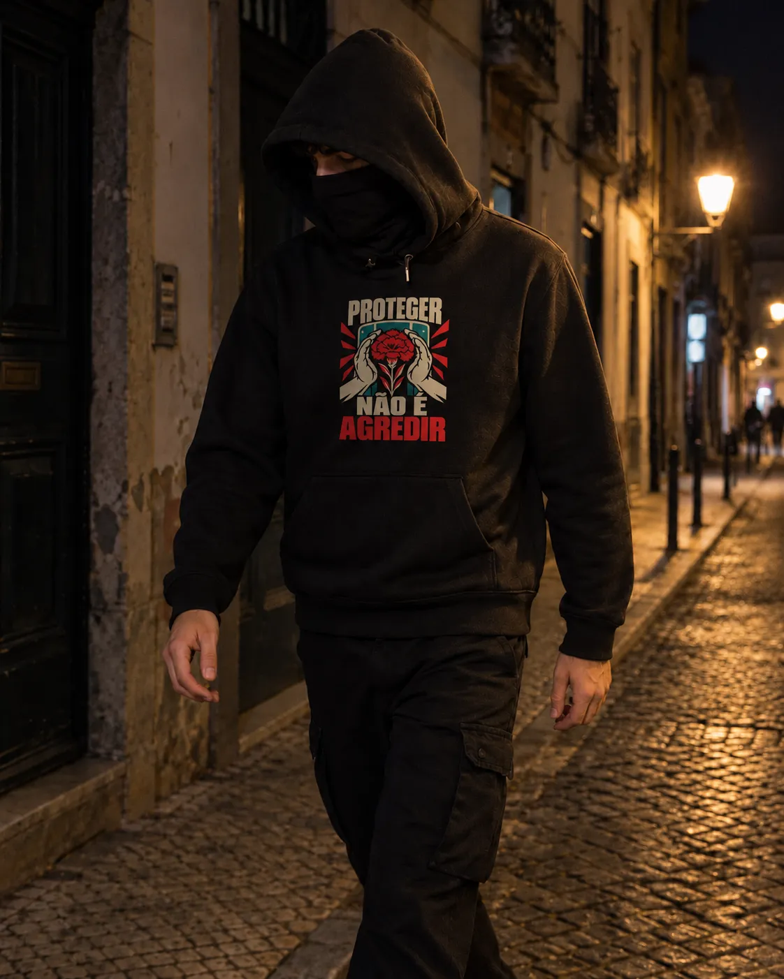 Pessoa a vestir o Hoodie Proteger Não É Agredir em preto, numa rua de Lisboa à noite